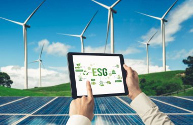 Çevre tasarrufu ve ESG iş konsepti için yeşil iş dönüşümü. İşadamı, çevre dostu yönetime ve alternatif temiz enerji kullanımına yönelik kurumsal bir hedef belirlemek için tablet kullanıyor.