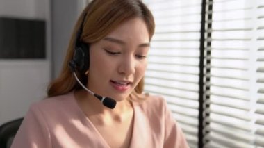 Competent female operator working on computer and while talking with clients. Concept relevant to both call centers and customer service offices.