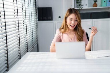 A young female employee receives a promotion, good news or finished her task and overjoyed for being a competent worker.