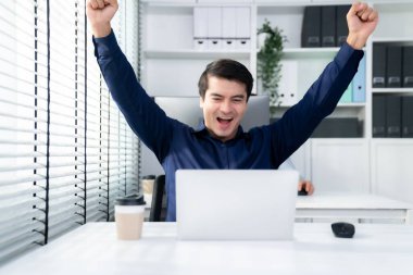 Young male employee receives a promotion, good news or finished his task and overjoyed for being a competent worker. Idea of promotion in career, reward for working hard worker.