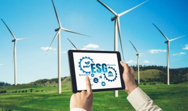 Çevre tasarrufu ve ESG iş konsepti için yeşil iş dönüşümü. İşadamı, çevre dostu yönetime ve alternatif temiz enerji kullanımına yönelik kurumsal bir hedef belirlemek için tablet kullanıyor.