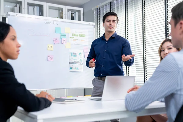 Competent office workers from various nationalities are debating, discussing and brainstorming in the meeting room. A group of employees is collaborating to achieve their business objectives.