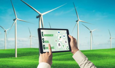 Çevre tasarrufu ve ESG iş konsepti için yeşil iş dönüşümü. İşadamı, çevre dostu yönetime ve alternatif temiz enerji kullanımına yönelik kurumsal bir hedef belirlemek için tablet kullanıyor.