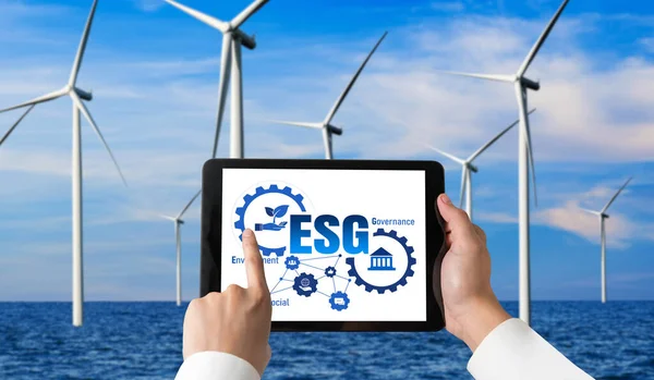 Green business transformation for environment saving and ESG business concept. Businessman using tablet to set corporate goal toward environmental friendly management and alternative clean energy use.