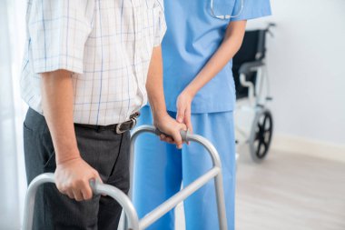 Physiotherapist assists contented senior man on folding walker. Recuperation for elderly, seniors care, nursing home.
