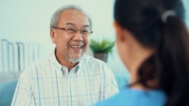 A young female doctor inquires about personal information of a contented senior at home. Medical care for the elderly, elderly illness, and nursing homes, home care.