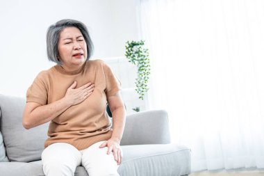 An agonizing elderly woman is experiencing chest pain. Medical attention, senior care service.