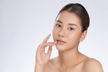 Portrait of gorgeous young girl posing beauty gesture with healthy clear skin and soft makeup. Cosmetology and beauty concept.