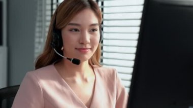 Competent female operator working on computer and while talking with clients. Concept relevant to both call centers and customer service offices.