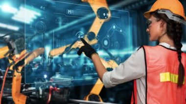 Engineer use cybernated robotic software to control industry robot arm in factory . Automation manufacturing process controlled by specialist using IOT software connected to internet network .