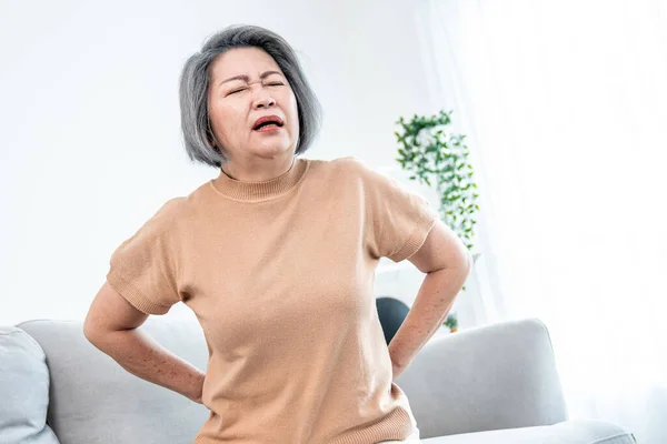 Agonizing Senior Woman Experiencing Back Pain While Sitting Her Sofa — Stok fotoğraf