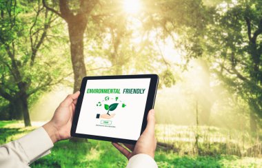 Çevre tasarrufu ve ESG iş konsepti için yeşil iş dönüşümü. İşadamı, çevre dostu yönetime ve alternatif temiz enerji kullanımına yönelik kurumsal bir hedef belirlemek için tablet kullanıyor.