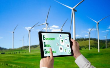 Çevre tasarrufu ve ESG iş konsepti için yeşil iş dönüşümü. İşadamı, çevre dostu yönetime ve alternatif temiz enerji kullanımına yönelik kurumsal bir hedef belirlemek için tablet kullanıyor.