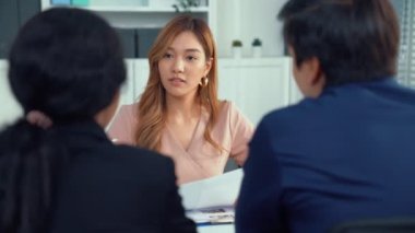 A young female asian candidate tries to impress her interviewer by being competent. International company, multicultural environment in workplace.