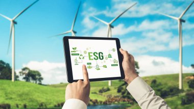 Çevre tasarrufu ve ESG iş konsepti için yeşil iş dönüşümü. İşadamı, çevre dostu yönetime ve alternatif temiz enerji kullanımına yönelik kurumsal bir hedef belirlemek için tablet kullanıyor.