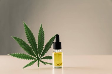 Kenevir sativa kenevir yaprağı ve beyaz arka planda damla kapağı olan CBD yağı. Yasallaştırılmış marihuana kavramı.