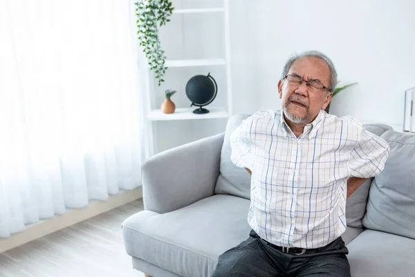 Agonizing Senior Man Need Assistance While Sitting His Sofa Home — Stockfoto