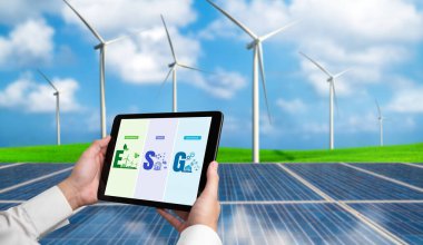 Çevre tasarrufu ve ESG iş konsepti için yeşil iş dönüşümü. İşadamı, çevre dostu yönetime ve alternatif temiz enerji kullanımına yönelik kurumsal bir hedef belirlemek için tablet kullanıyor.