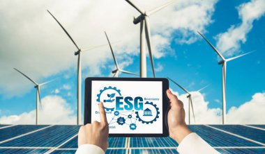 Çevre tasarrufu ve ESG iş konsepti için yeşil iş dönüşümü. İşadamı, çevre dostu yönetime ve alternatif temiz enerji kullanımına yönelik kurumsal bir hedef belirlemek için tablet kullanıyor.