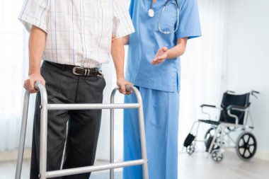 Physiotherapist assists contented senior man on folding walker. Recuperation for elderly, seniors care, nursing home.