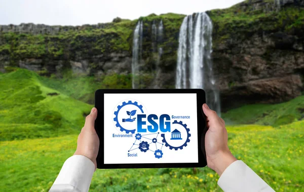 Green business transformation for environment saving and ESG business concept. Businessman using tablet to set corporate goal toward environmental friendly management and alternative clean energy use.