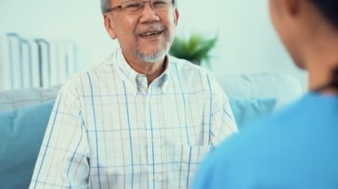 A young female doctor inquires about personal information of a contented senior at home. Medical care for the elderly, elderly illness, and nursing homes, home care.