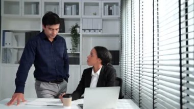 Concept of experienced and competent coworker, employer, supervisor giving advice to a young female office worker. Teamwork between coworkers, leadership company, multiracial in workspace.