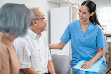 Female doctor visiting a contented elderly couple at their home. Health care, senior health support staff.
