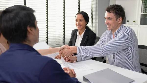 Commercial contract signed by competent people of various ethnicities and shake hands. Trade agreements, two-party business transactions.