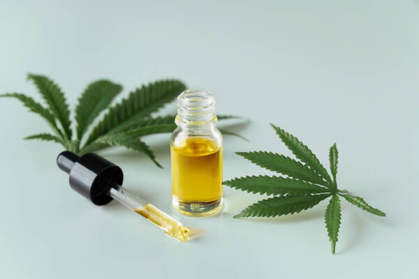 Лист конопли конопли конопли конопли с контейнером масла CBD с крышкой капельницы на белом фоне. Легализованная марихуана.