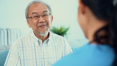 A young female doctor inquires about personal information of a contented senior at home. Medical care for the elderly, elderly illness, and nursing homes, home care.