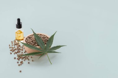 Marihuana 'dan çıkarılan cam kapaklı marihuana yağı ve boş arkaplanda kenevir tohumları içeren yasallaştırılmış marihuana konsepti. Copyspace ve reklam için marihuana ürünleri.