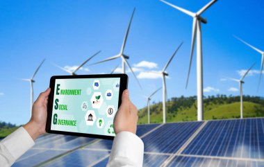 Çevre tasarrufu ve ESG iş konsepti için yeşil iş dönüşümü. İşadamı, çevre dostu yönetime ve alternatif temiz enerji kullanımına yönelik kurumsal bir hedef belirlemek için tablet kullanıyor.