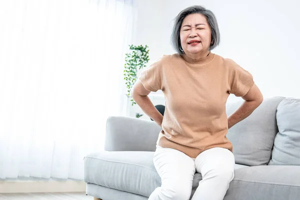 Agonizing Senior Woman Experiencing Back Pain While Sitting Her Sofa — 图库照片