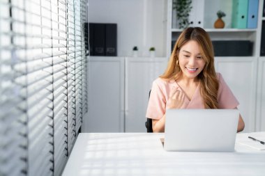 A young female employee receives a promotion, good news or finished her task and overjoyed for being a competent worker.