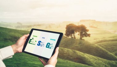 Çevre tasarrufu ve ESG iş konsepti için yeşil iş dönüşümü. İşadamı, çevre dostu yönetime ve alternatif temiz enerji kullanımına yönelik kurumsal bir hedef belirlemek için tablet kullanıyor.
