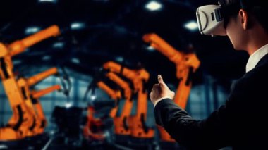 Engineer use cybernated robotic software to control industry robot arm in factory . Automation manufacturing process controlled by specialist using IOT software connected to internet network .