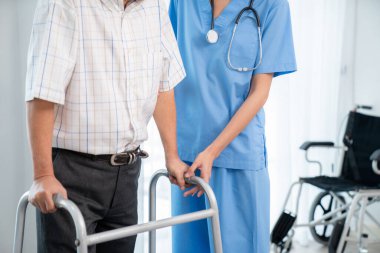 Physiotherapist assists her contented senior patient on folding walker. Recuperation for elderly, seniors care, nursing home.