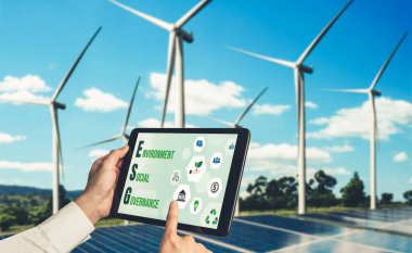Çevre tasarrufu ve ESG iş konsepti için yeşil iş dönüşümü. İşadamı, çevre dostu yönetime ve alternatif temiz enerji kullanımına yönelik kurumsal bir hedef belirlemek için tablet kullanıyor.