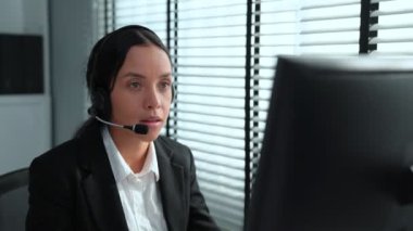 Competent african american female operator working on computer and while talking with clients. Concept relevant to both call centers and customer service offices.