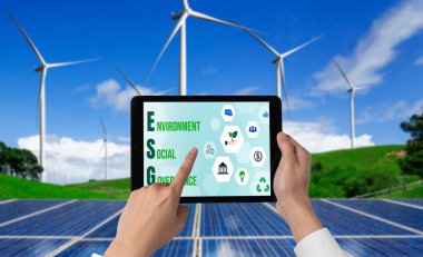 Çevre tasarrufu ve ESG iş konsepti için yeşil iş dönüşümü. İşadamı, çevre dostu yönetime ve alternatif temiz enerji kullanımına yönelik kurumsal bir hedef belirlemek için tablet kullanıyor.
