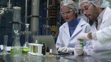 Two scientist in professional uniform working in curative laboratory for chemical and biomedical experiment