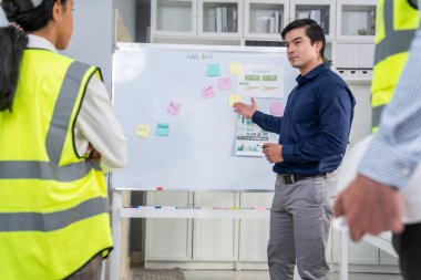A team of investor and competent engineers brainstorming on the whiteboard to find new ideas and making plans. The idea of a team gather ideas together.