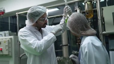 Kimyasal ve biyomedikal deneyler için tedavi laboratuvarında çalışan profesyonel üniformalı iki bilim adamı.