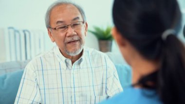 A young female doctor inquires about personal information of a contented senior at home. Medical care for the elderly, elderly illness, and nursing homes, home care.