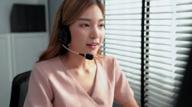 Competent female operator working on computer and while talking with clients. Concept relevant to both call centers and customer service offices.