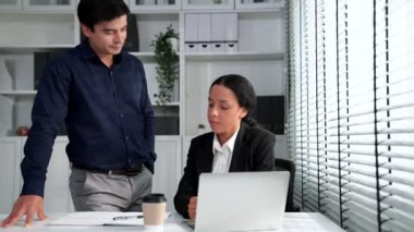 Concept of experienced and competent coworker, employer, supervisor giving advice to a young female office worker. Teamwork between coworkers, leadership company, multiracial in workspace.