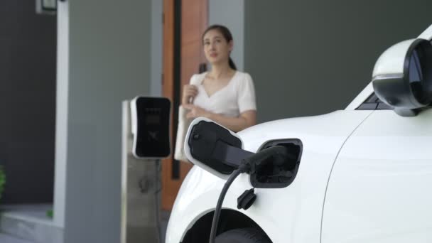 Femeie Deconectează Încărcătorul Vehicule Electrice Reședința Conceptul Utilizare Vehiculelor Electrice — Videoclip de stoc