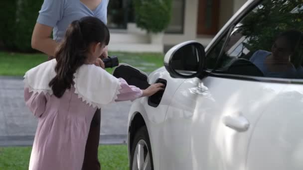 母亲和女儿的进步生活方式 他们刚从学校乘电动汽车回来 在家里充电 可持续清洁能源驱动的电动汽车 — 图库视频影像