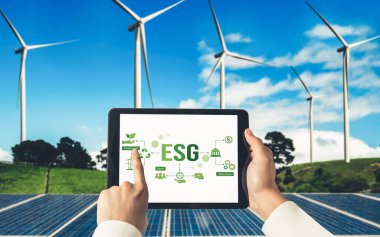 Çevre tasarrufu ve ESG iş konsepti için yeşil iş dönüşümü. İşadamı, çevre dostu yönetime ve alternatif temiz enerji kullanımına yönelik kurumsal bir hedef belirlemek için tablet kullanıyor.